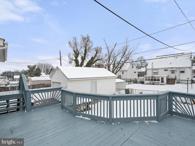 snow covered deck featuring a garage and an outdoor structure