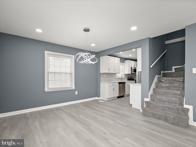 interior space featuring a notable chandelier and light wood-type flooring