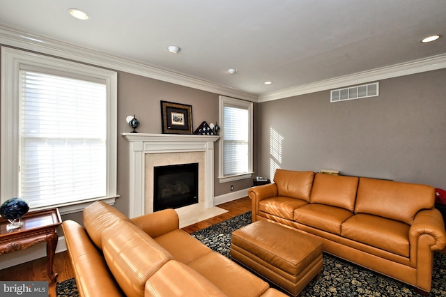 living room with crown molding, a premium fireplace, and hardwood / wood-style flooring