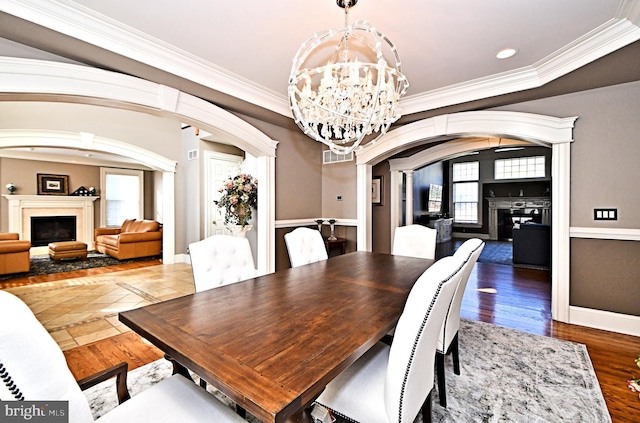 dining room with crown molding, a notable chandelier, and hardwood / wood-style flooring