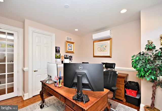 home office featuring an AC wall unit and light wood-type flooring