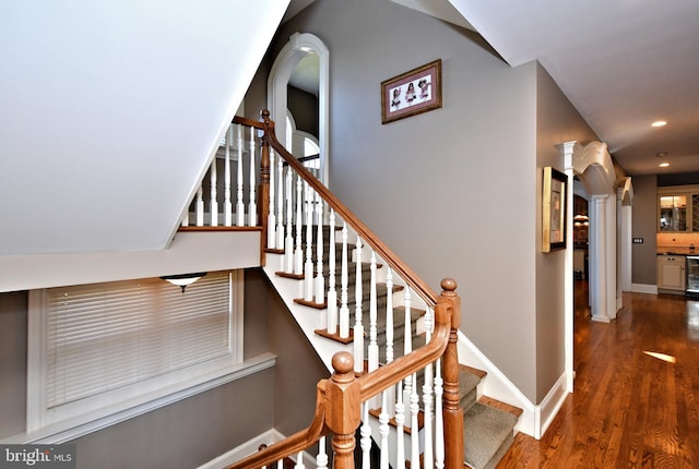 stairway featuring wine cooler and hardwood / wood-style flooring