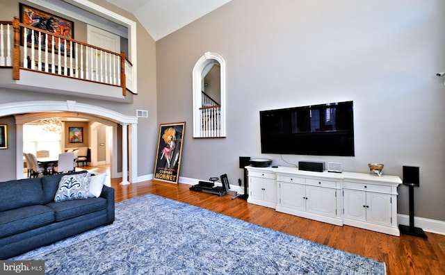 living room featuring dark hardwood / wood-style flooring and high vaulted ceiling