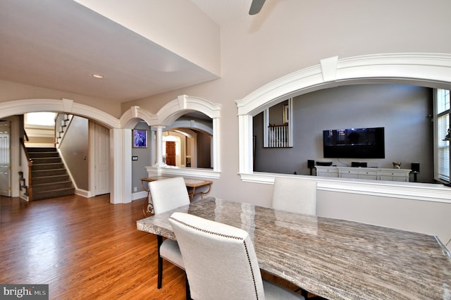 dining space featuring wood-type flooring and decorative columns