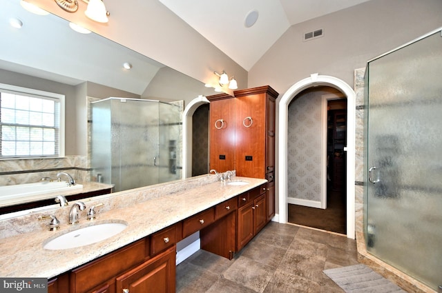 bathroom with lofted ceiling, vanity, and plus walk in shower