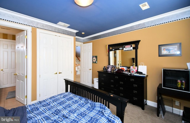 tiled bedroom with crown molding and a closet