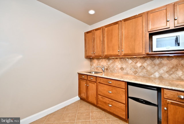 kitchen with stainless steel fridge, sink, decorative backsplash, and light tile patterned floors