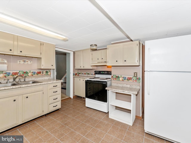 kitchen with white fridge, sink, electric range, and cream cabinetry