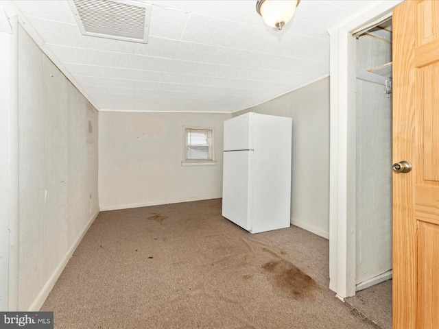 interior space featuring carpet flooring and white fridge