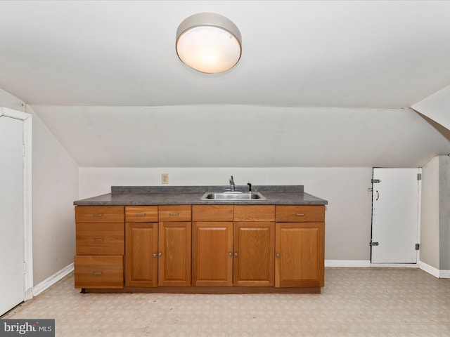 bathroom featuring lofted ceiling and sink