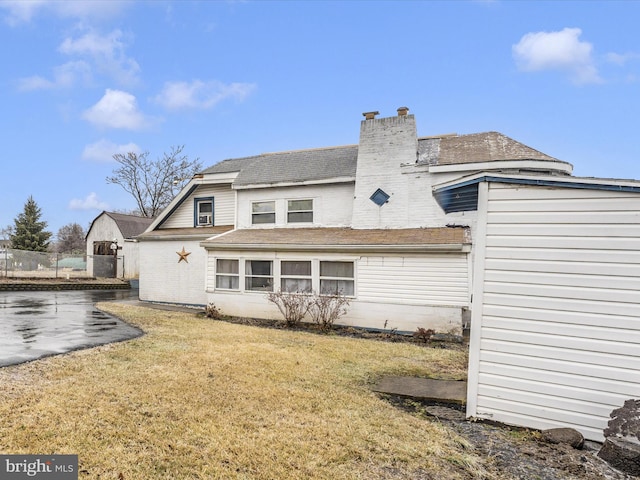 rear view of house featuring a yard