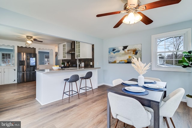 dining room with ceiling fan and light wood-type flooring