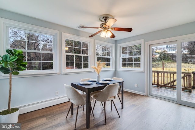 sunroom with plenty of natural light, ceiling fan, and baseboard heating