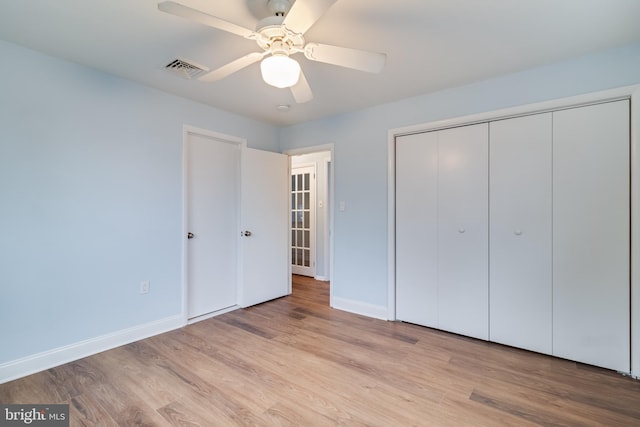 unfurnished bedroom featuring ceiling fan, a closet, and light hardwood / wood-style flooring