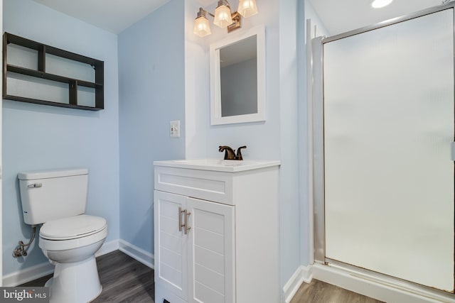 bathroom featuring vanity, hardwood / wood-style floors, toilet, and walk in shower