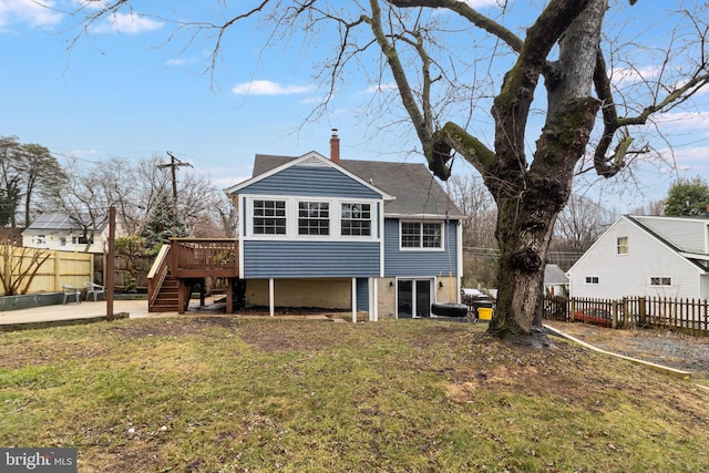 back of property with a lawn and a deck