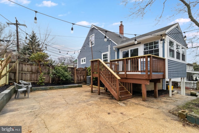 rear view of property with a deck and a patio