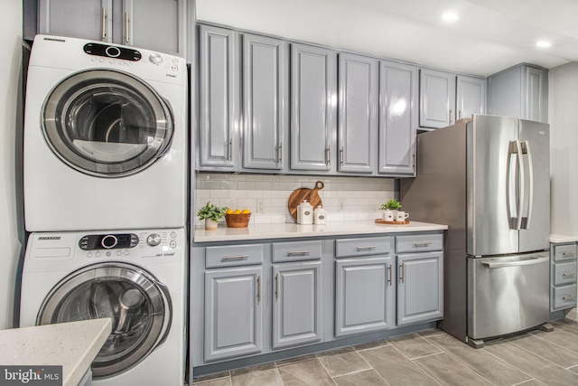 clothes washing area with stacked washer / dryer