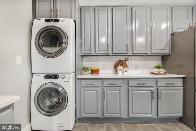 laundry room featuring cabinets and stacked washer and dryer