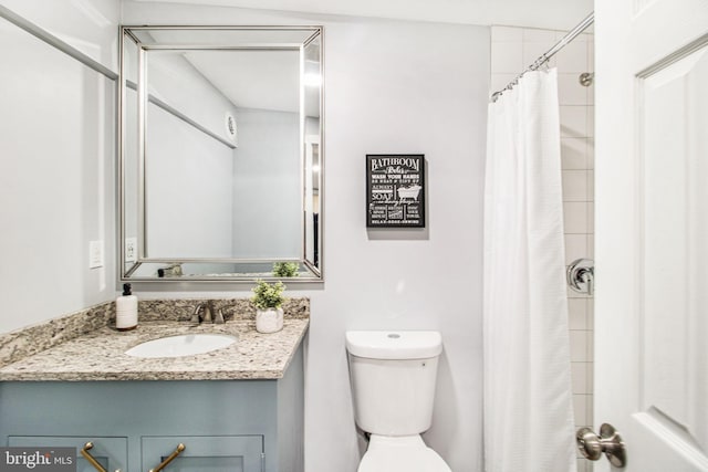 bathroom featuring vanity, curtained shower, and toilet