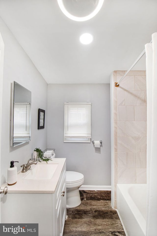 full bathroom featuring vanity, tiled shower / bath combo, wood-type flooring, and toilet