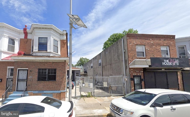 exterior space featuring a gate, fence, and brick siding