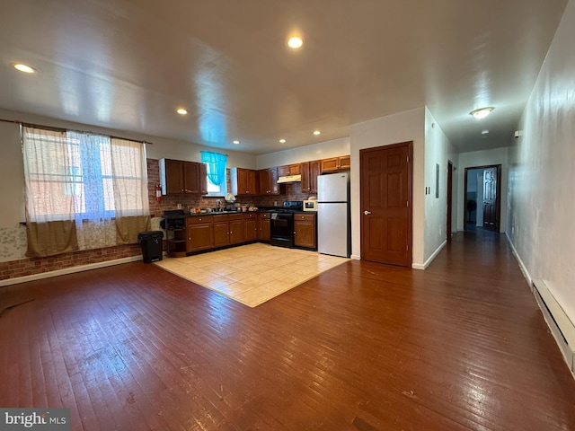 kitchen with brown cabinetry, freestanding refrigerator, range with electric stovetop, and light wood-style flooring