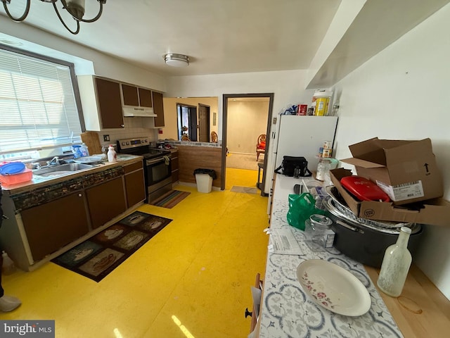 kitchen with electric range, a sink, dark brown cabinetry, and under cabinet range hood