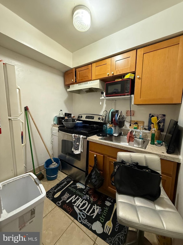 kitchen featuring brown cabinets, under cabinet range hood, stainless steel electric stove, and light countertops