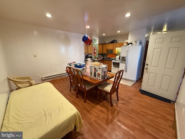 dining space with light wood-style floors, a baseboard heating unit, and recessed lighting