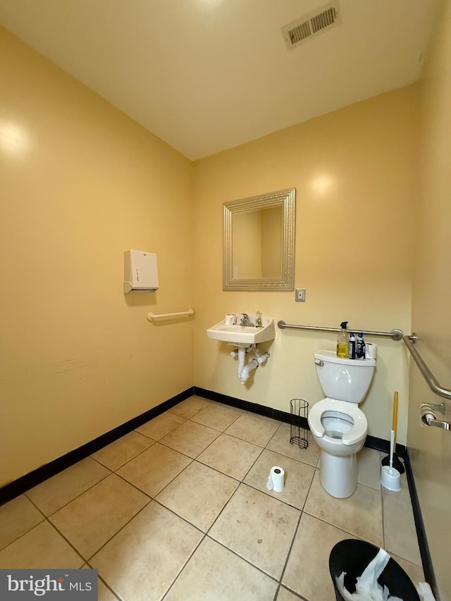 bathroom with a sink, tile patterned flooring, visible vents, and baseboards