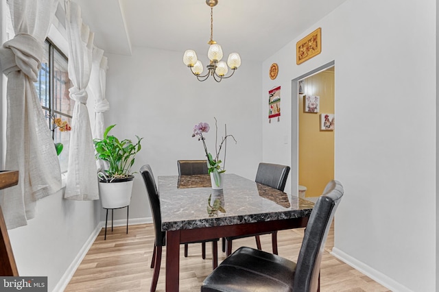 dining space with an inviting chandelier and light hardwood / wood-style flooring