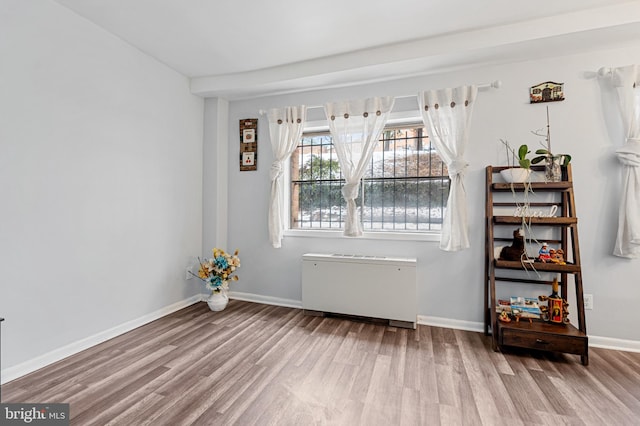 empty room featuring hardwood / wood-style flooring and radiator heating unit