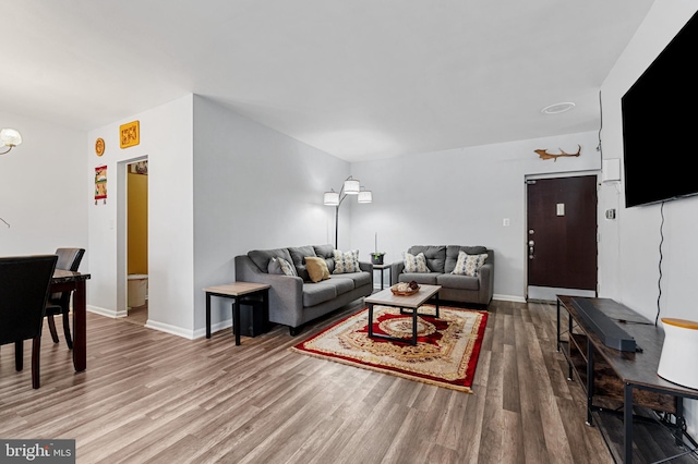 living room with hardwood / wood-style floors and a notable chandelier