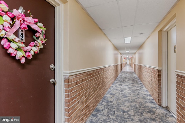 hall featuring a paneled ceiling