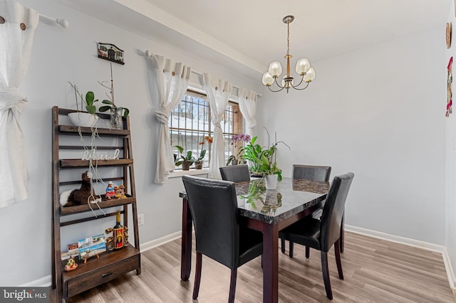 dining space with hardwood / wood-style flooring and a notable chandelier