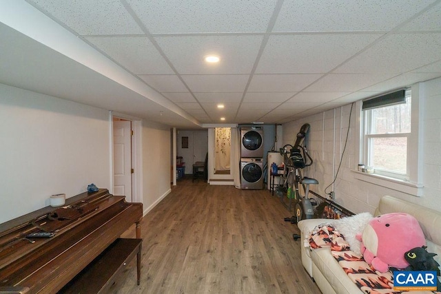 interior space featuring stacked washing maching and dryer, wood-type flooring, and a paneled ceiling