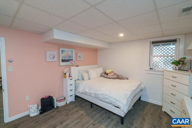 bedroom featuring dark hardwood / wood-style floors and a drop ceiling