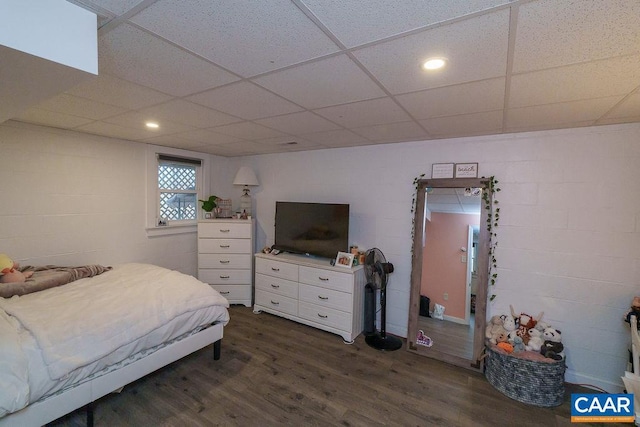 bedroom featuring dark wood-type flooring and a drop ceiling