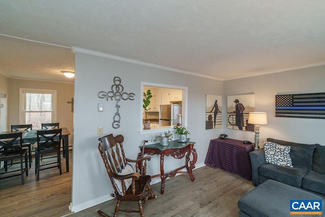 living room with crown molding, hardwood / wood-style flooring, and a textured ceiling