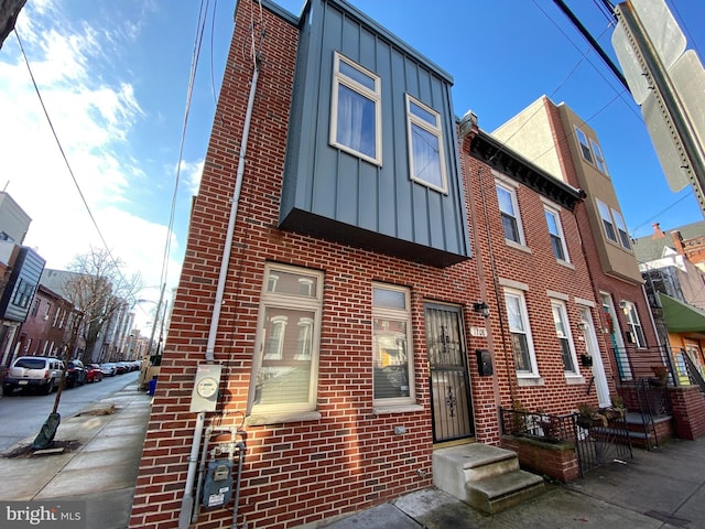 view of front facade featuring brick siding and board and batten siding