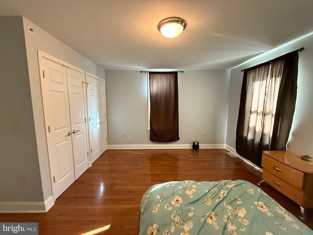 bedroom with dark wood finished floors and baseboards