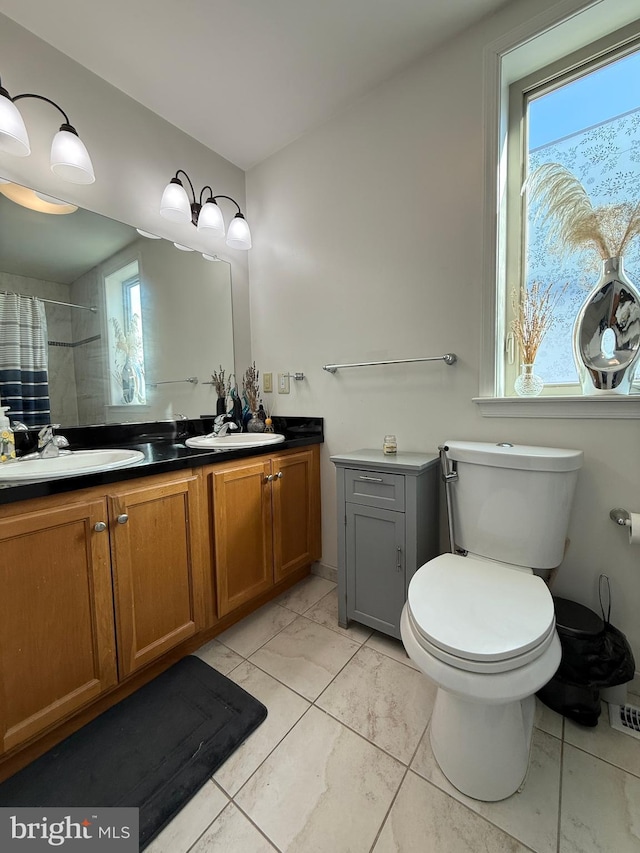 full bathroom featuring double vanity, toilet, a shower with curtain, marble finish floor, and a sink