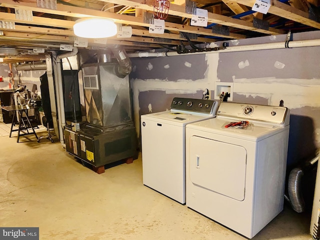 washroom with laundry area, separate washer and dryer, and visible vents