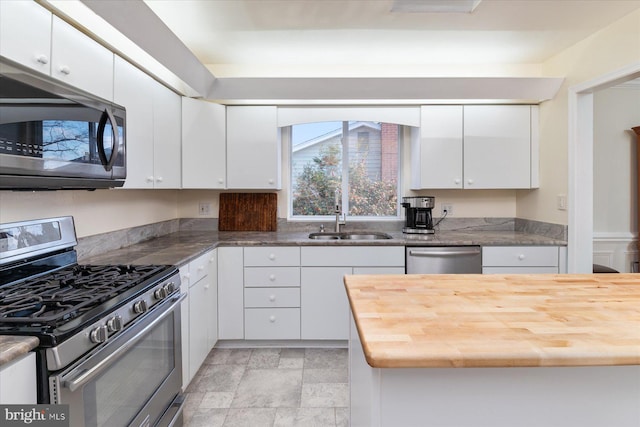 kitchen featuring sink, white cabinets, stainless steel appliances, and butcher block counters