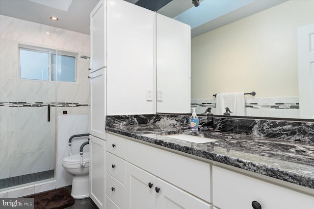 bathroom with toilet, vanity, and walk in shower