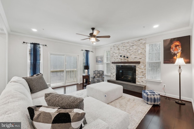 living room featuring crown molding, ceiling fan, a fireplace, and hardwood / wood-style floors