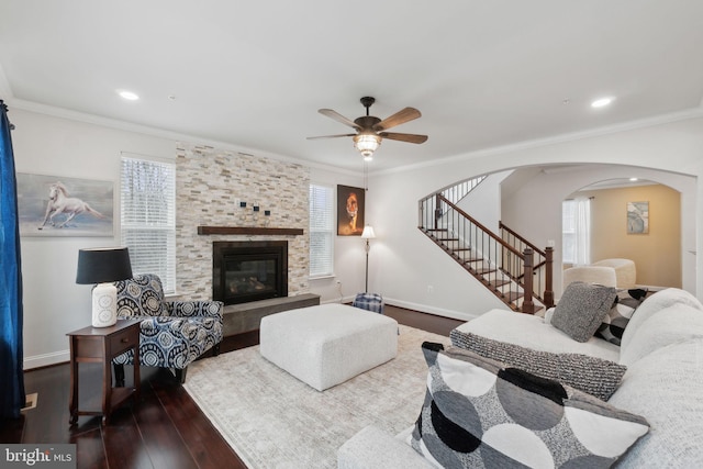 living room with ornamental molding, ceiling fan, a fireplace, and dark hardwood / wood-style flooring