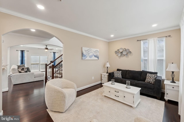 living room with crown molding, ceiling fan, and light wood-type flooring