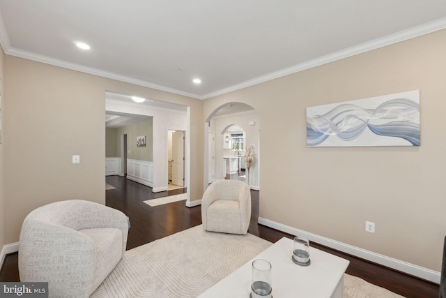 sitting room with crown molding and dark wood-type flooring